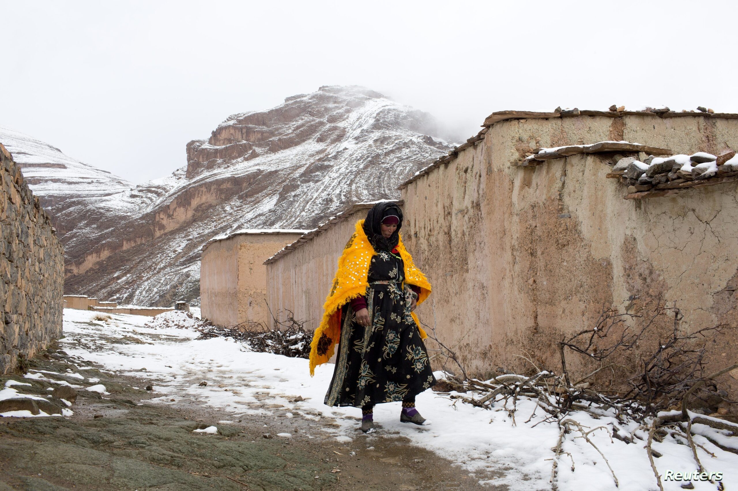A woman walks through the snow covered village of Tilmi in the High Atlas region of Morocco February 13, 2015. The snowy foothills of the High Atlas mountains in Morocco are home to several Berber villages where the inhabitants make their living by farming, baking bread in traditional ovens, herding cattle, and the making and selling of honey, olive oil and pottery. Extreme weather fluctuations and erosion that causes flooding and landslides have led to a drop in agricultural productivity, the United Nations said. REUTERS/Youssef Boudlal (MOROCCO - Tags: TRAVEL SOCIETY) ATTENTION EDITORS: PICTURE 04 OF 24 FOR WIDER IMAGE PACKAGE 'LIFE IN THE ATLAS MOUNTAINS' TO FIND ALL IMAGES SEARCH 'ATLAS BOUDLAL'